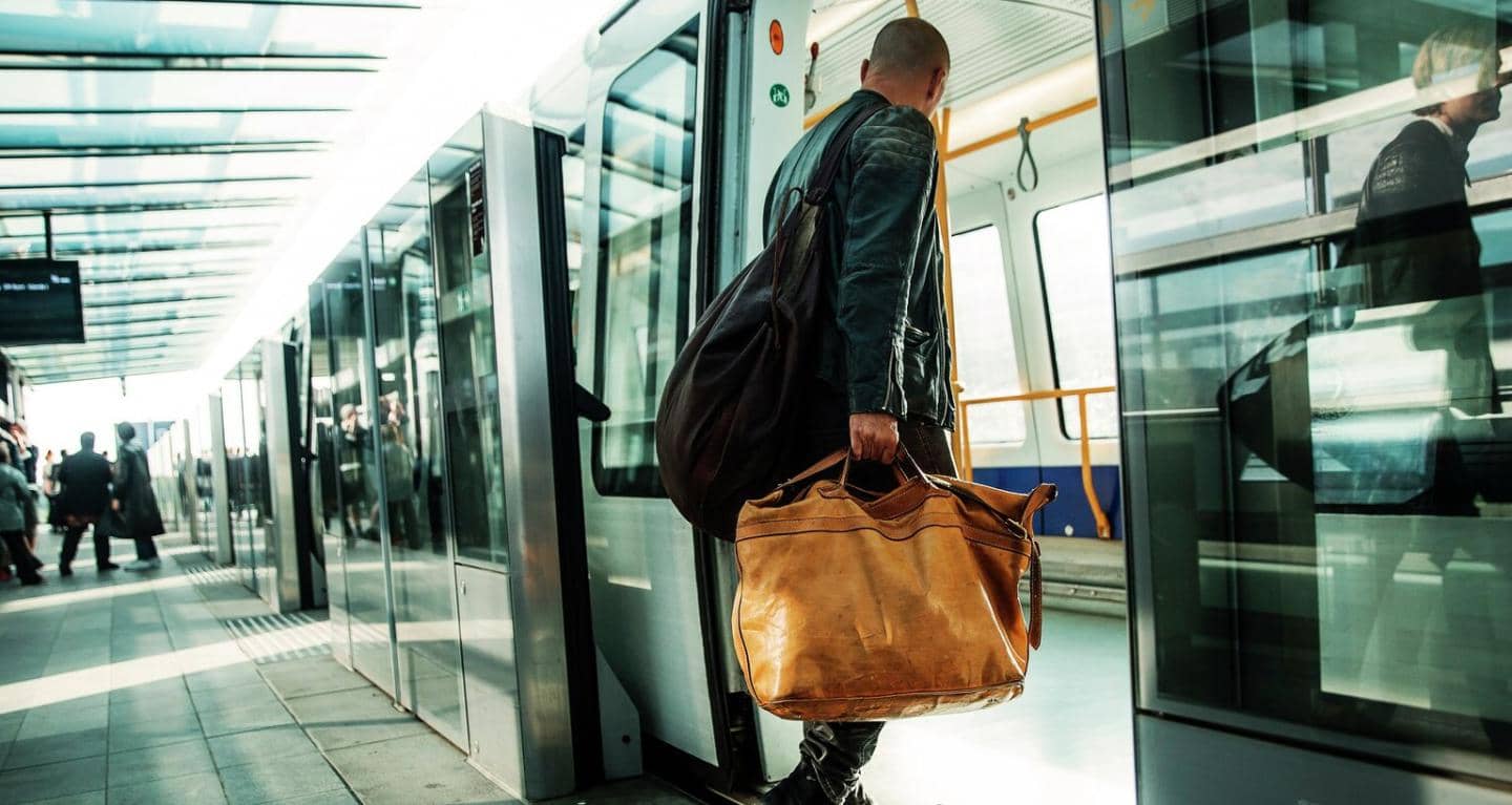 Mand går ind i metro med taske i hånden
