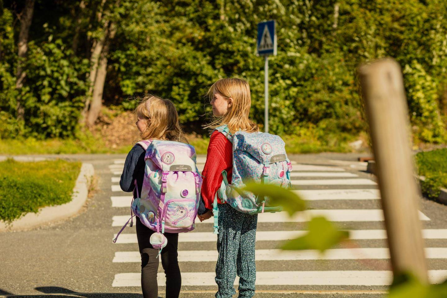 To piger ved fodgængerovergang med skoletasker på, fotografi